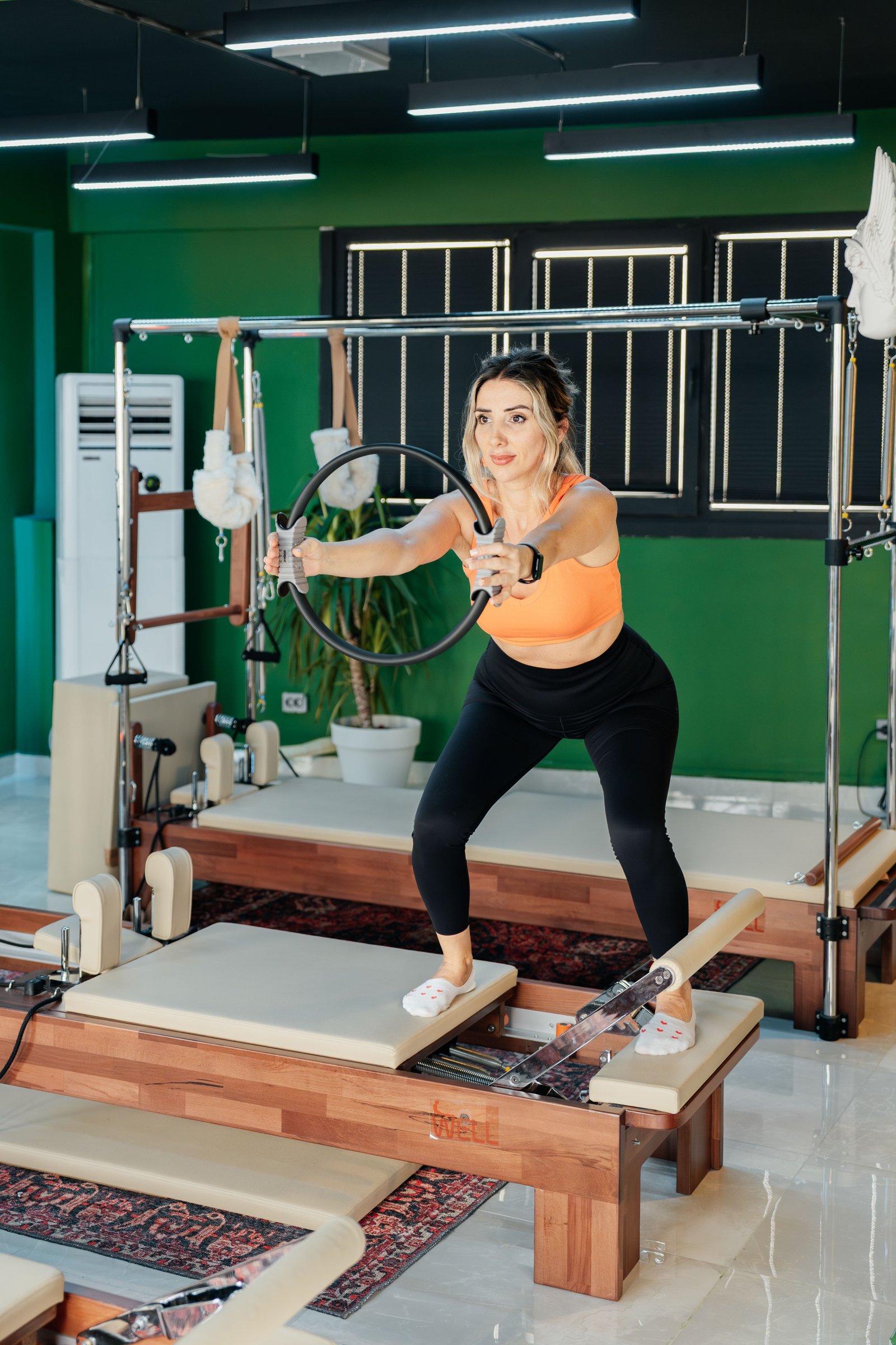 Aluna praticando Pilates com atenção à postura, em estúdio com luz natural